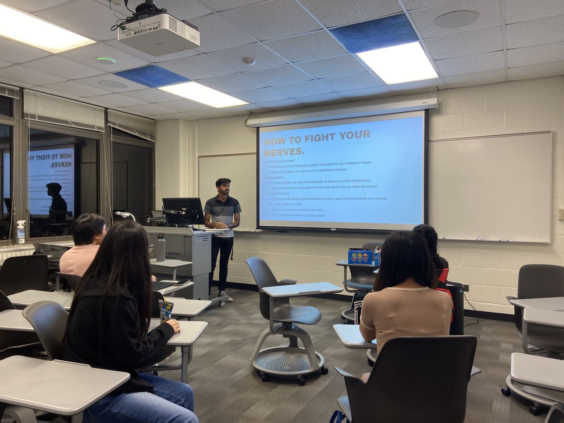 A SASE GT member presenting a public-speaking workshop slide to students in a Georgia Tech classroom.